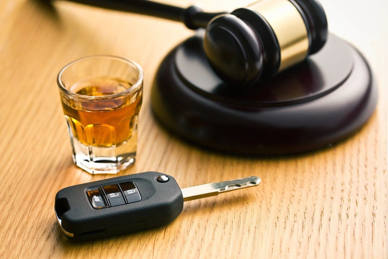A car key, and a drink are on the table.